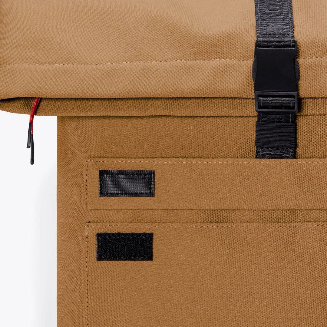 Detailansicht des Ucon Acrobatics Phantom Jannik Rucksacks – Dark Sand Reflect mit aufgesetztem Frontfach mit Klettverschluss