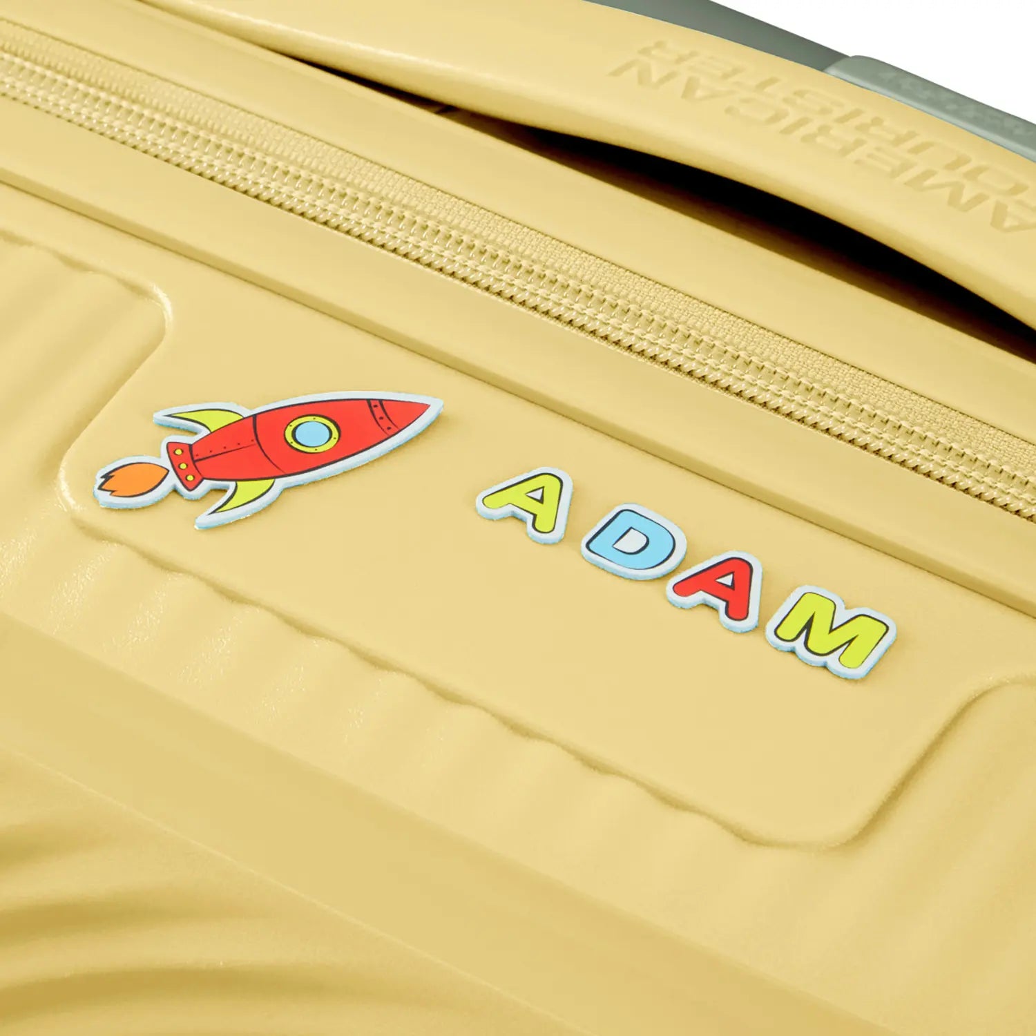 Detailbild von bunten Stickern auf dem hellgelben Trolley von American Tourister