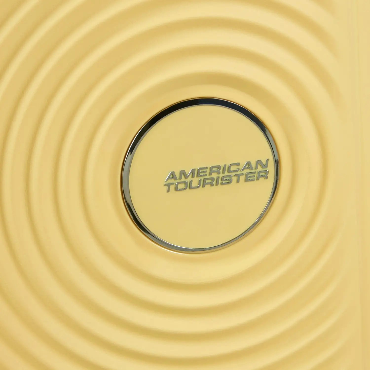 Nahaufnahme Logo vom hellgelben Soundbox Mini Koffer von American Tourister