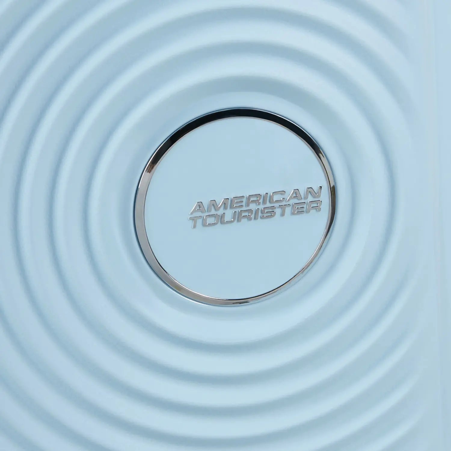 Silbernes American Tourister Logo auf blauem Trolley mit markantem kreisförmigen Design