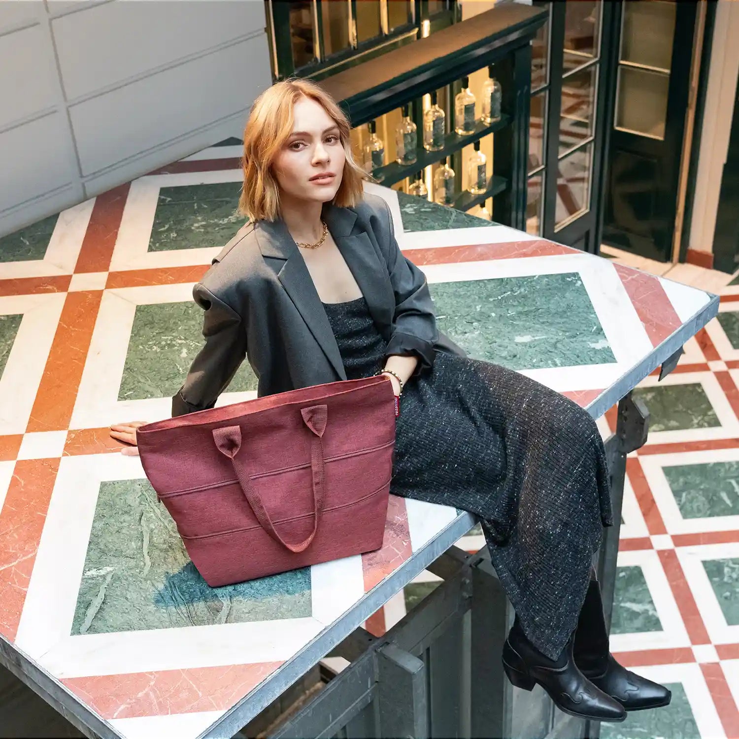 Lifestyle-Aufnahme Reisenthel Shopping Shopper e1 Twist Maroon – stilvolle Tragetasche für Stadt und Reisen