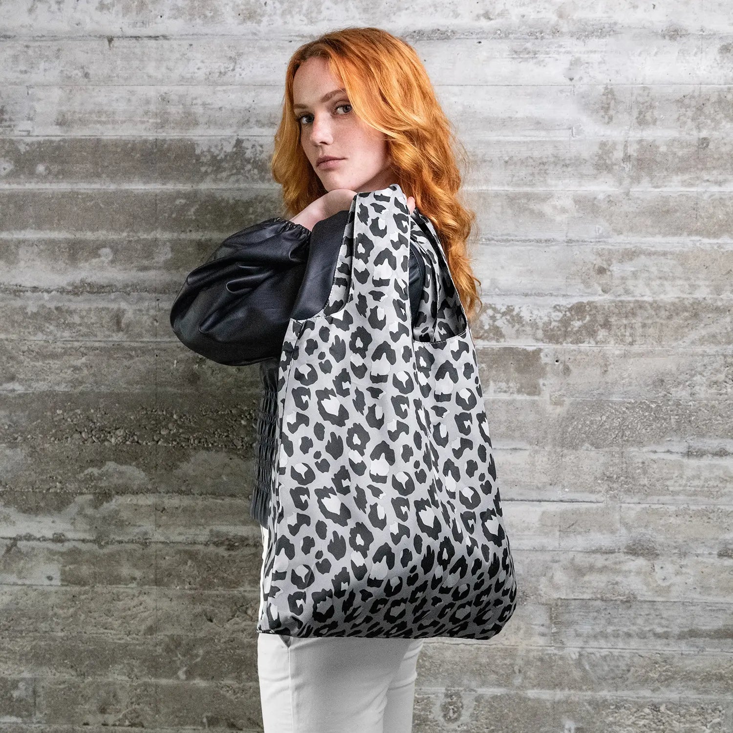 Reisenthel Mini Maxi Shopper AT7080 Leo Nero -Ansicht einer Frau mit der Tasche über der chulter - hochwertige Verarbeitung und elegantes Leopardenmuster